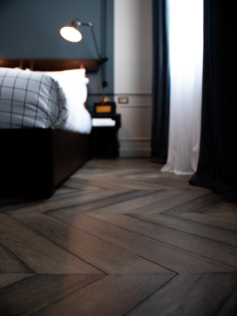Dark herringbone floor in a stylish bedroom