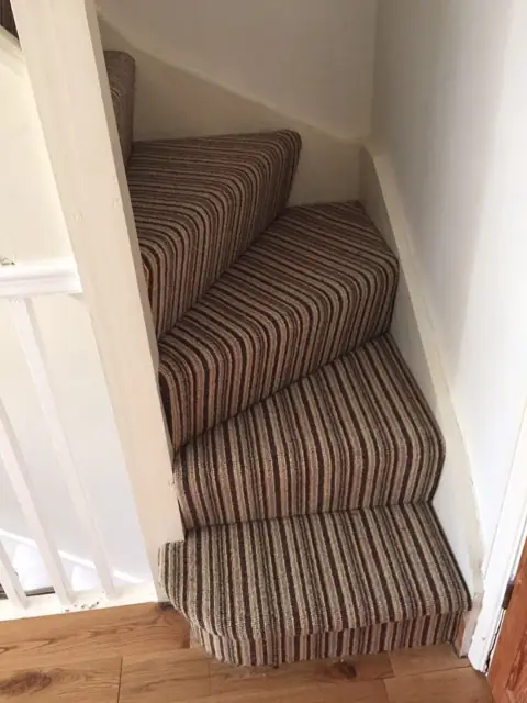 Winder stairs in a striped carpet